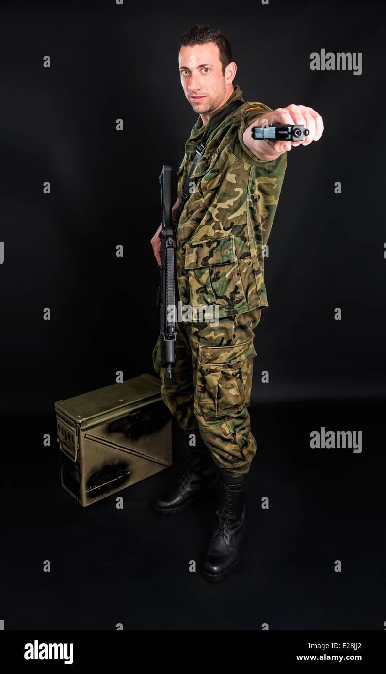 Militares españoles con SMG y pistola sobre fondo negro Foto de stock