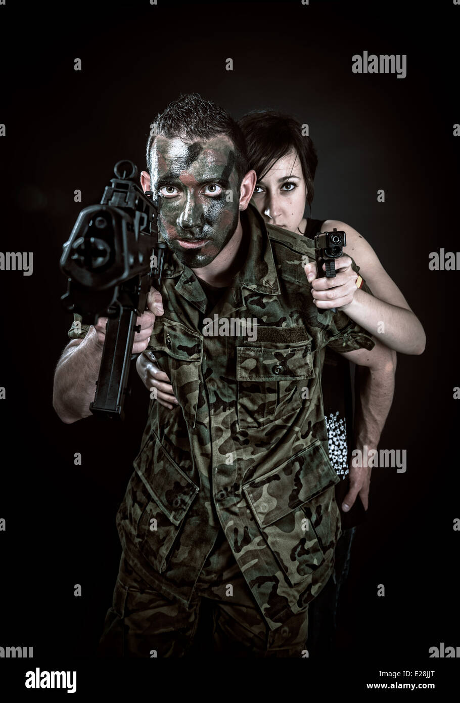 Militares españoles con SMG y chica con pistola sobre fondo negro Foto de stock