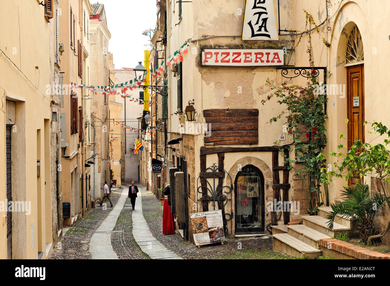 Italia, Cerdeña, provincia de Sassari, Alghero, Via Roma, caminando por una calle de adoquines en el centro histórico de la ciudad Foto de stock
