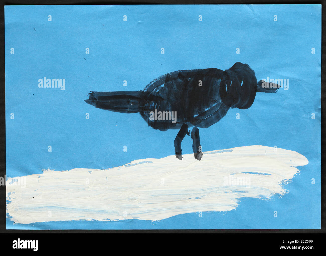 Niño original dibujo de un pájaro negro sobre blanco nieve dibujado por una niña de 5 años. Foto de stock