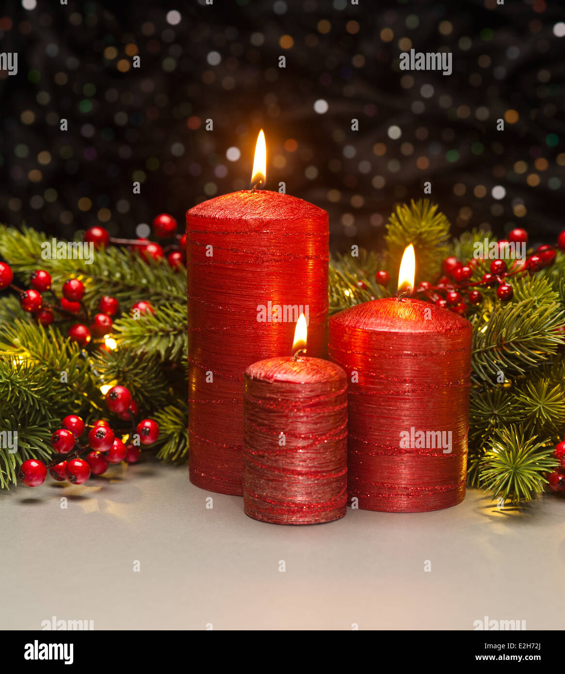 Tres velas rojas con ramas de árbol de Navidad y bayas rojas decoradas  Fotografía de stock - Alamy