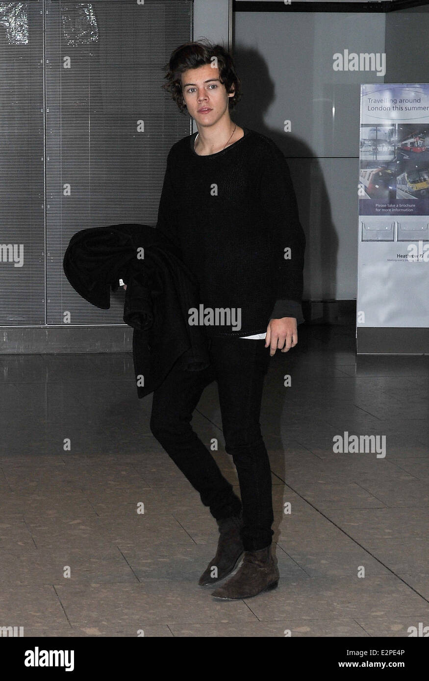 Una dirección Harry estilos llega al aeropuerto de Heathrow usando un  guante de tejido negro y puente skinny jeans con estilos: Harry donde:  Londres, Reino Unido cuando: 28 de enero de 2013