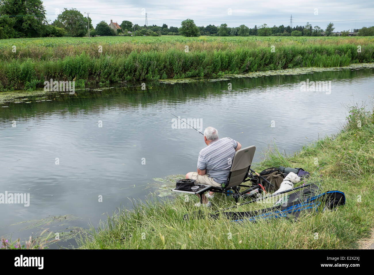 Pescador y amigo en la calma de un día por el río Cam Foto de stock