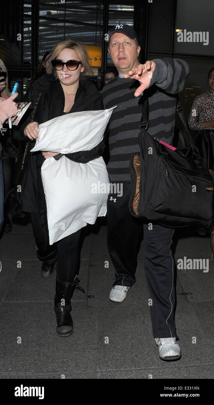 Demi Lovato llega al aeropuerto de Heathrow en un vuelo desde Los Ángeles.  Demi parecía cansada después de un largo vuelo, y fue agarrando una  almohada grande y con gafas de sol