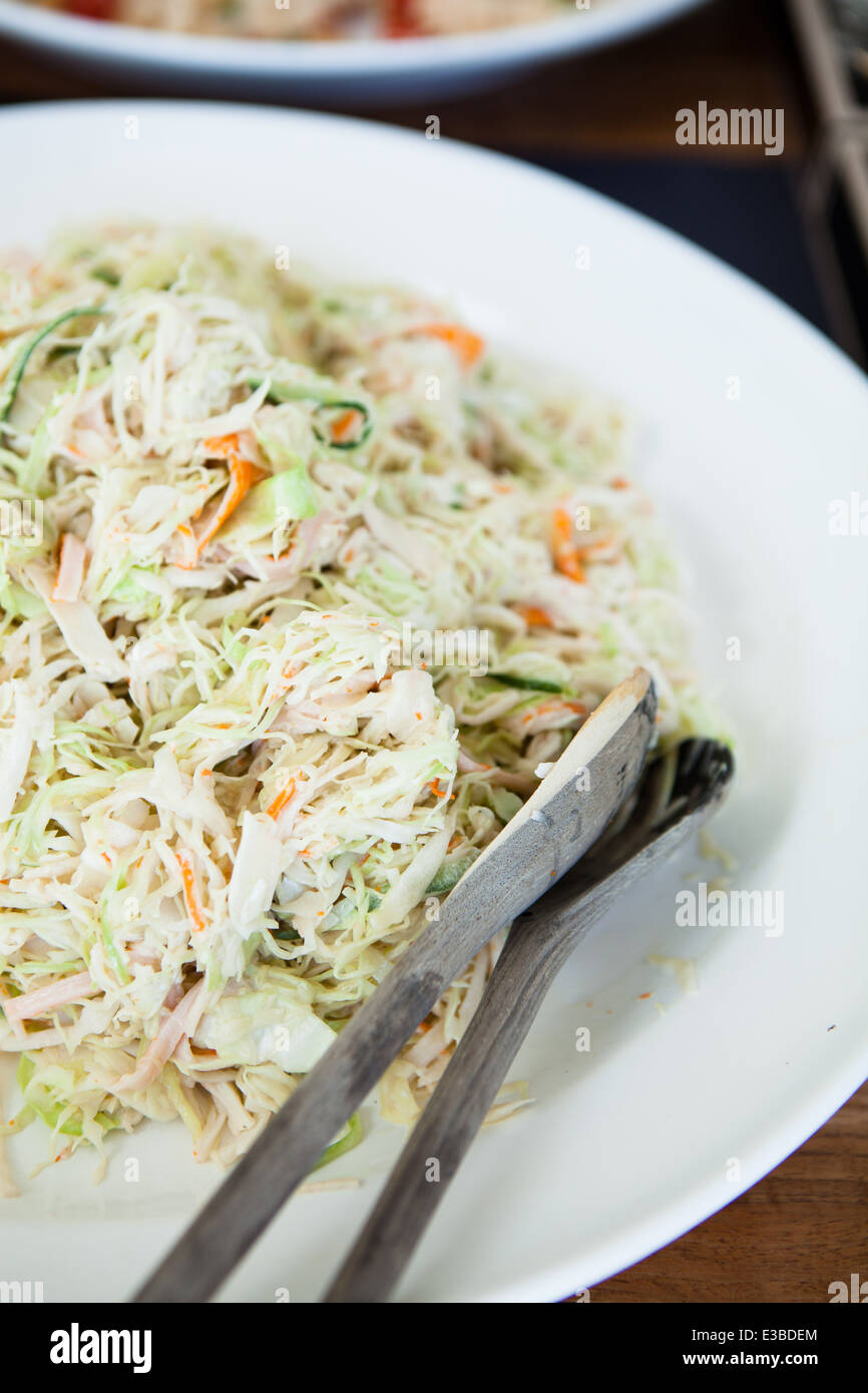 Primer plano de plato de ensalada coleslaw con cucharones de madera Foto de stock