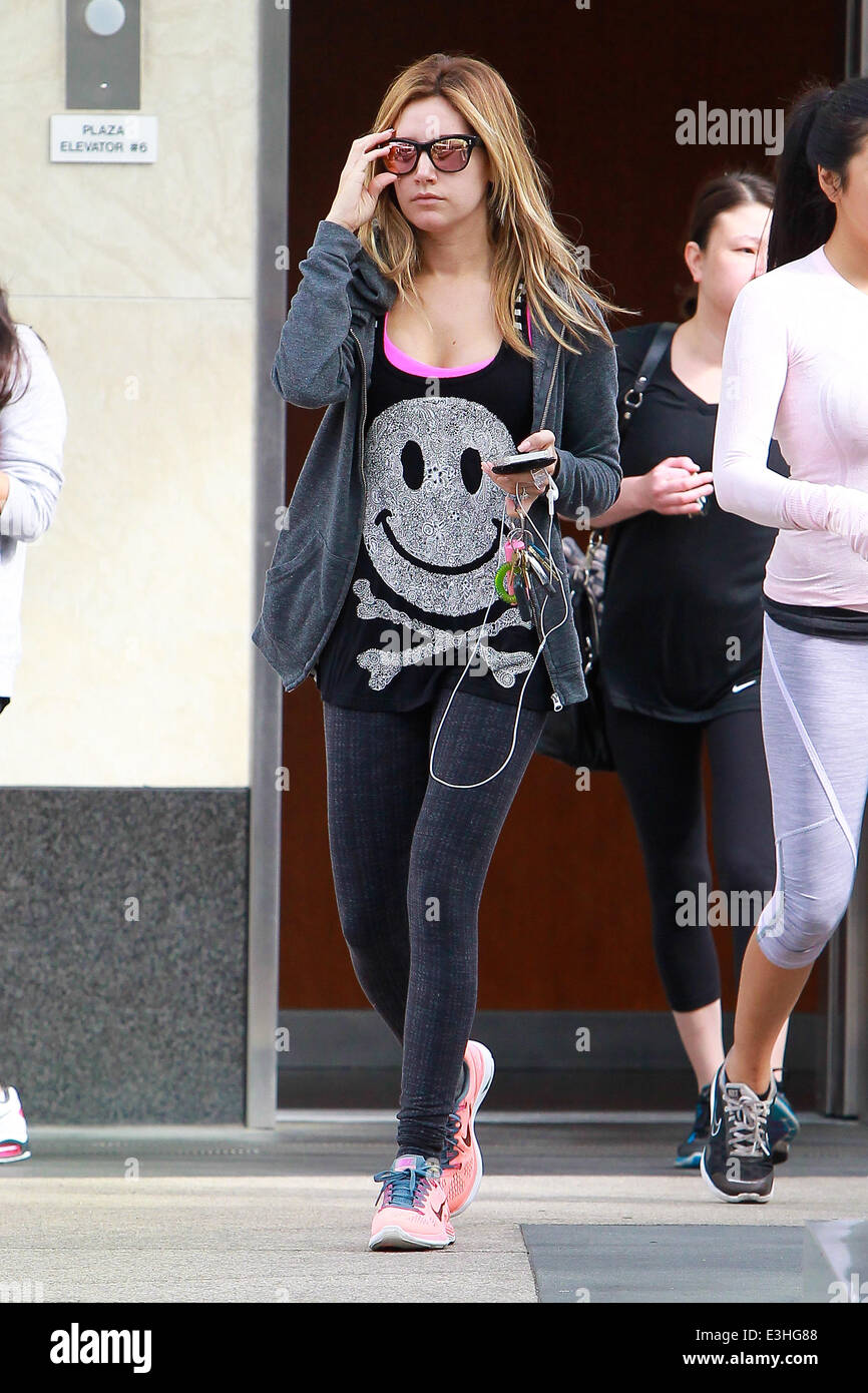 Ashley Tisdale va al gimnasio en West Hollywood luciendo gafas de sol  reflejada Tintada Rosa, Rosa Nike instructores y una cara sonriente y  huesos cruzados t-shirt mientras texting mientras camina con su
