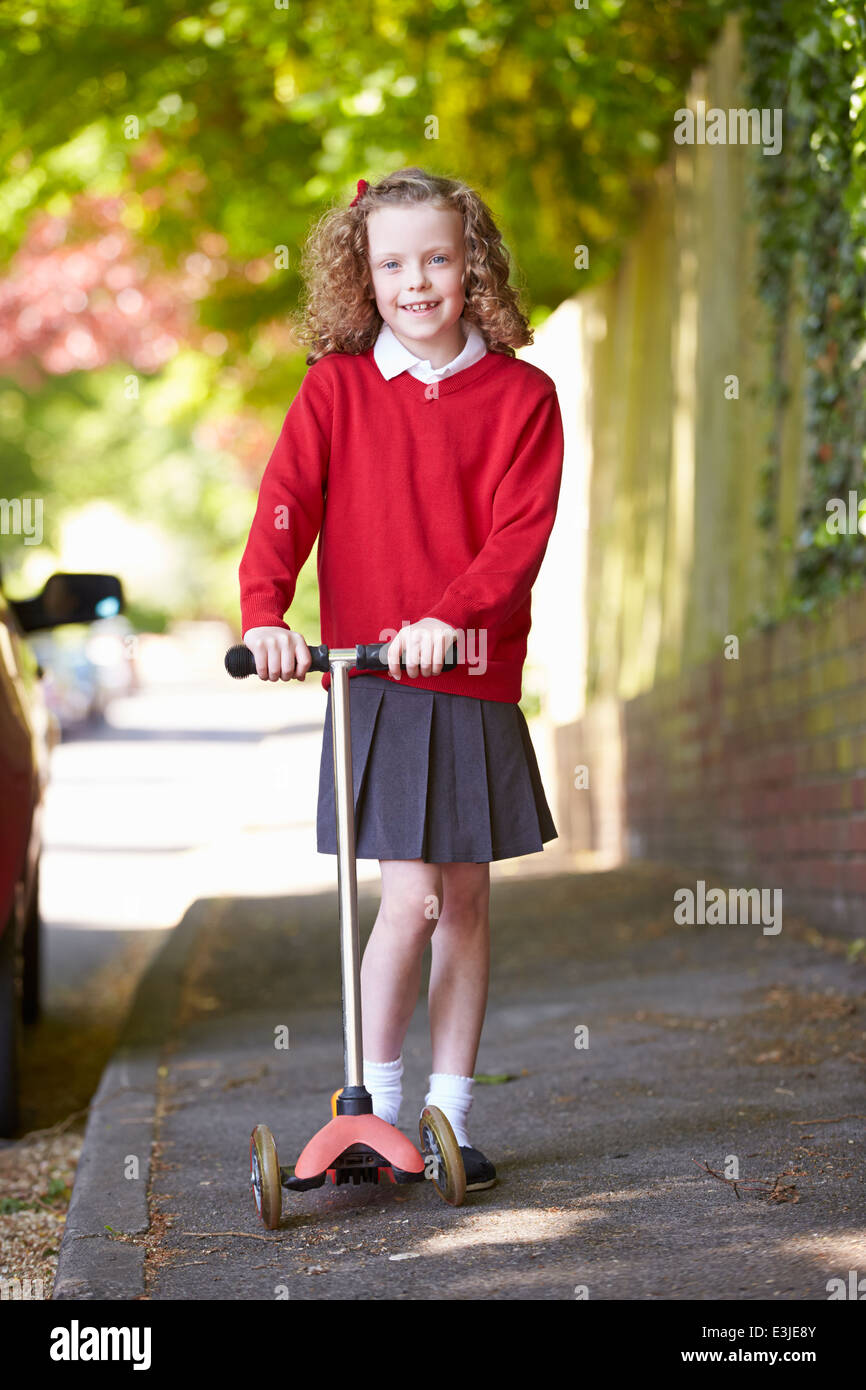 Joven hermosa estudiante asiática, con una mochila, camina en el parque con  un scooter eléctrico, en el verano en la calle Fotografía de stock - Alamy