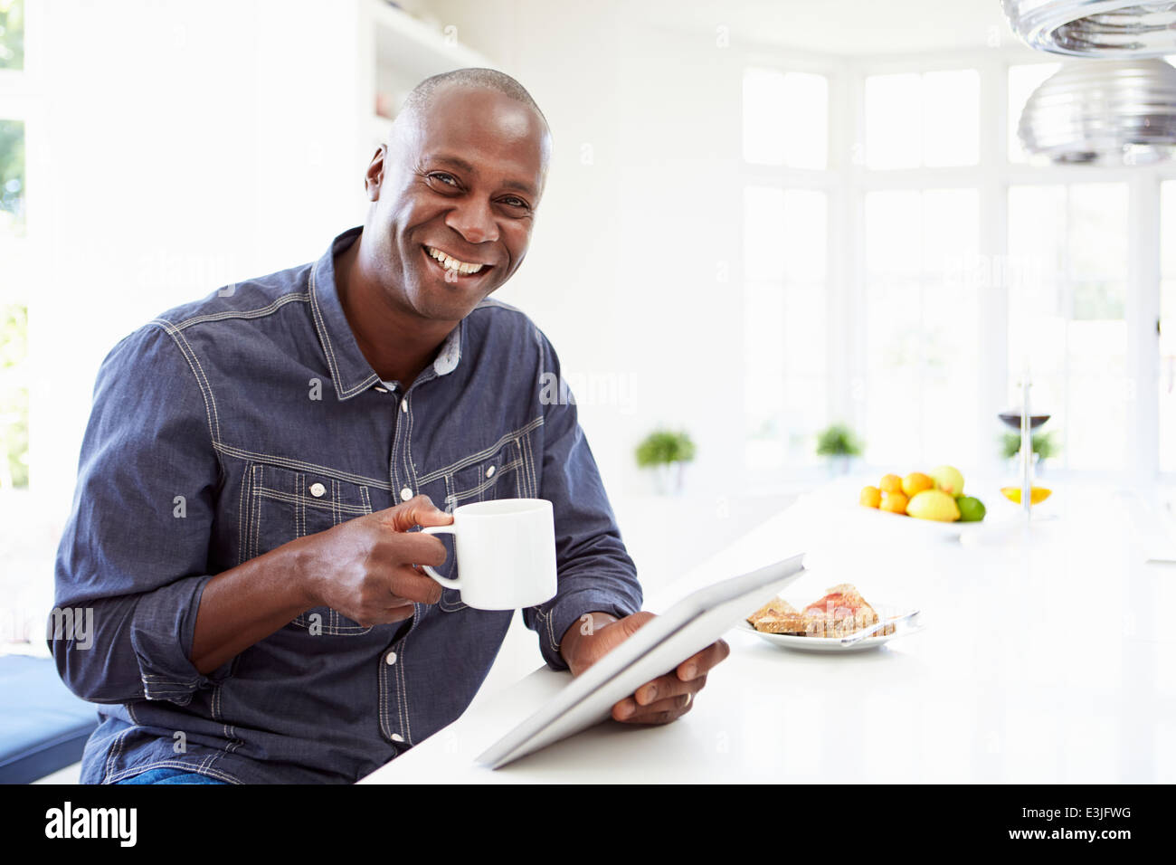 Hombre afroamericano mediante tableta digital en casa Foto de stock