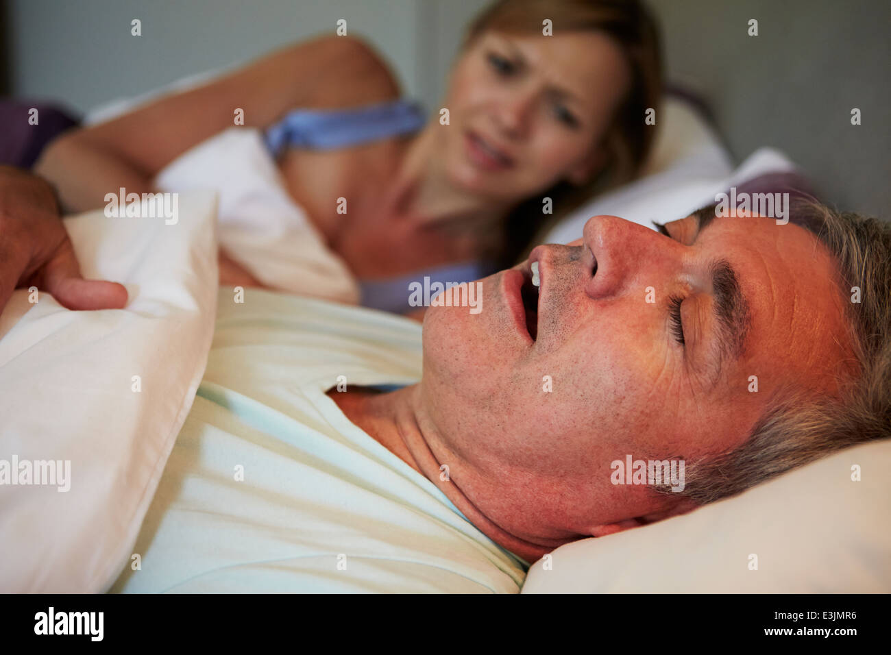 Hombre Mujer mantener despierto en la cama con ronquido Foto de stock