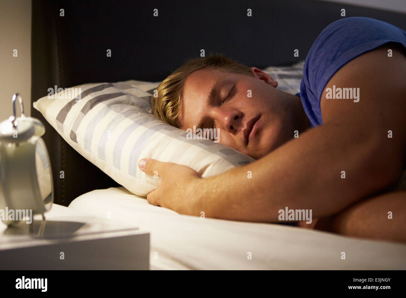 Adolescente dormido en la cama en la noche Foto de stock