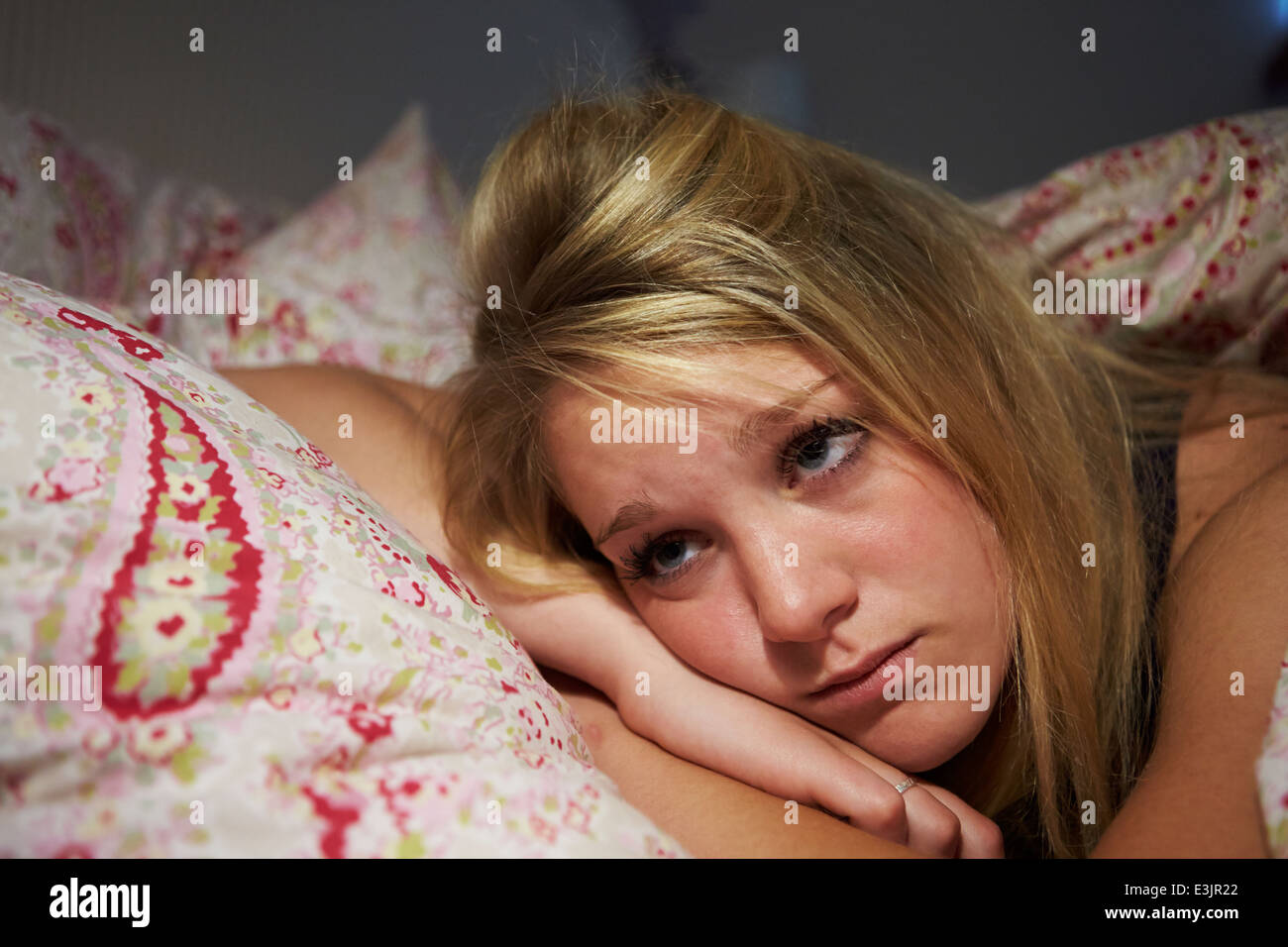 Adolescente despierto en la cama sufriendo con insomnio Foto de stock