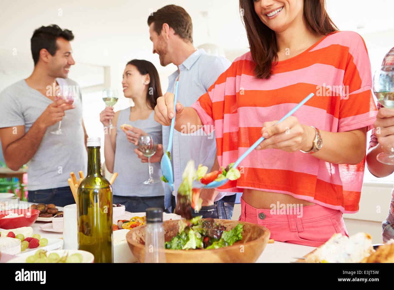 Grupo de Amigos con la cena y fiesta en casa Foto de stock