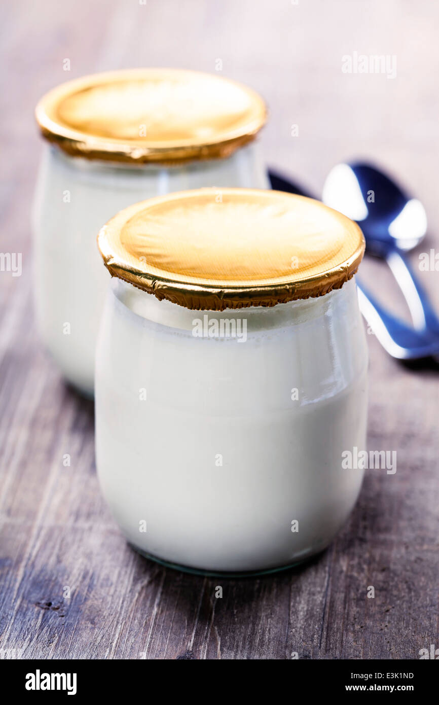 Crema agria o yogur natural con cucharas - concepto de dieta y salud Foto de stock