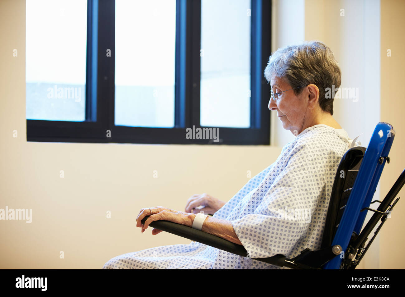 Paciente femenina Senior sentada sola en silla de ruedas Foto de stock