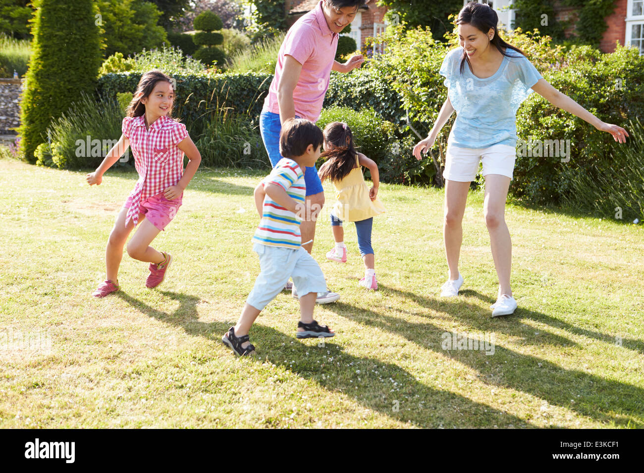 Familia de Asia jugando en el jardín de verano juntos Foto de stock