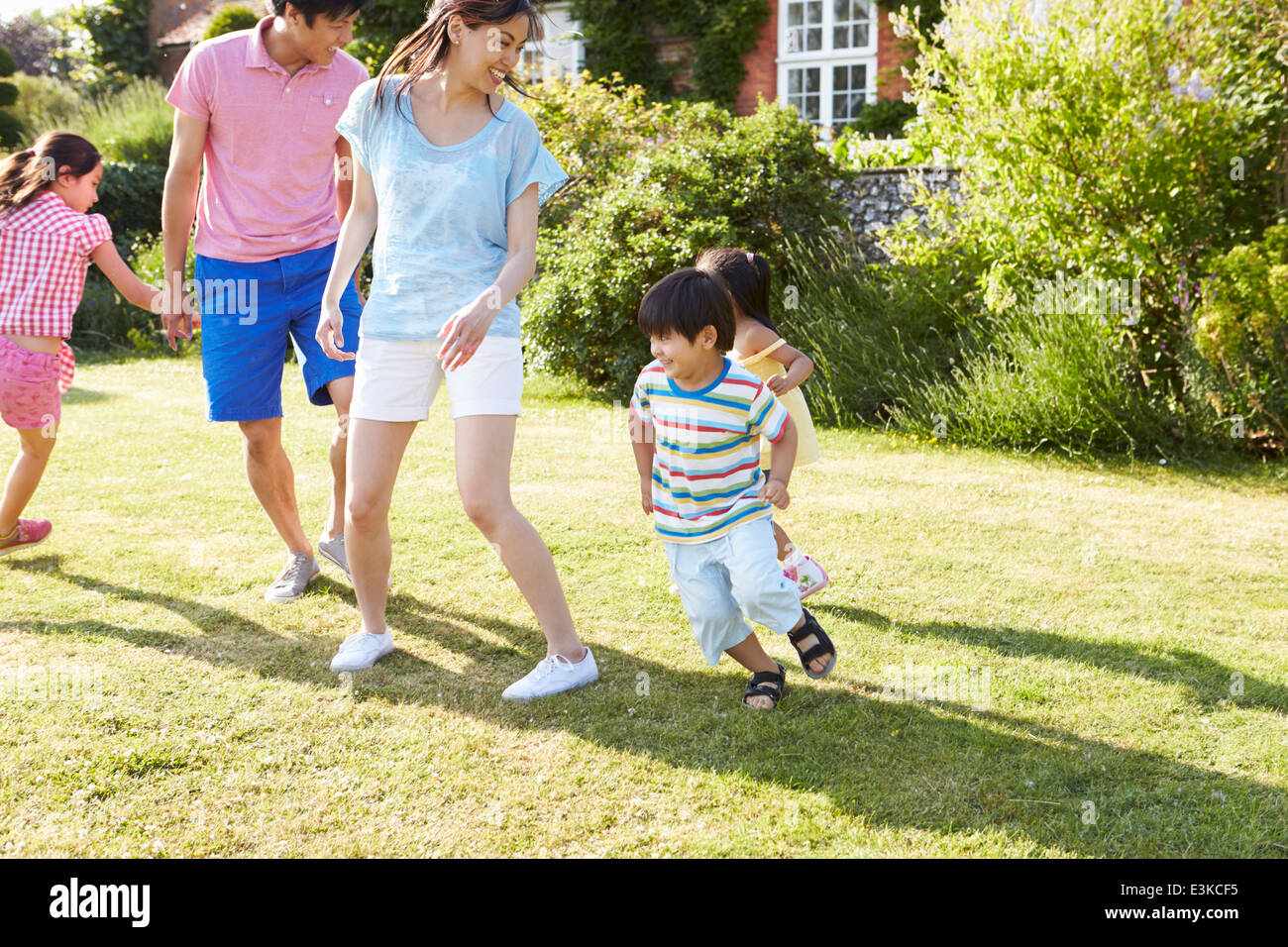 Familia de Asia jugando en el jardín de verano juntos Foto de stock