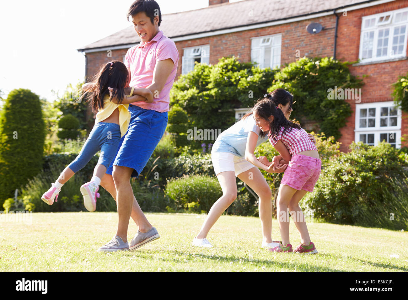 Familia de Asia jugando en el jardín de verano juntos Foto de stock