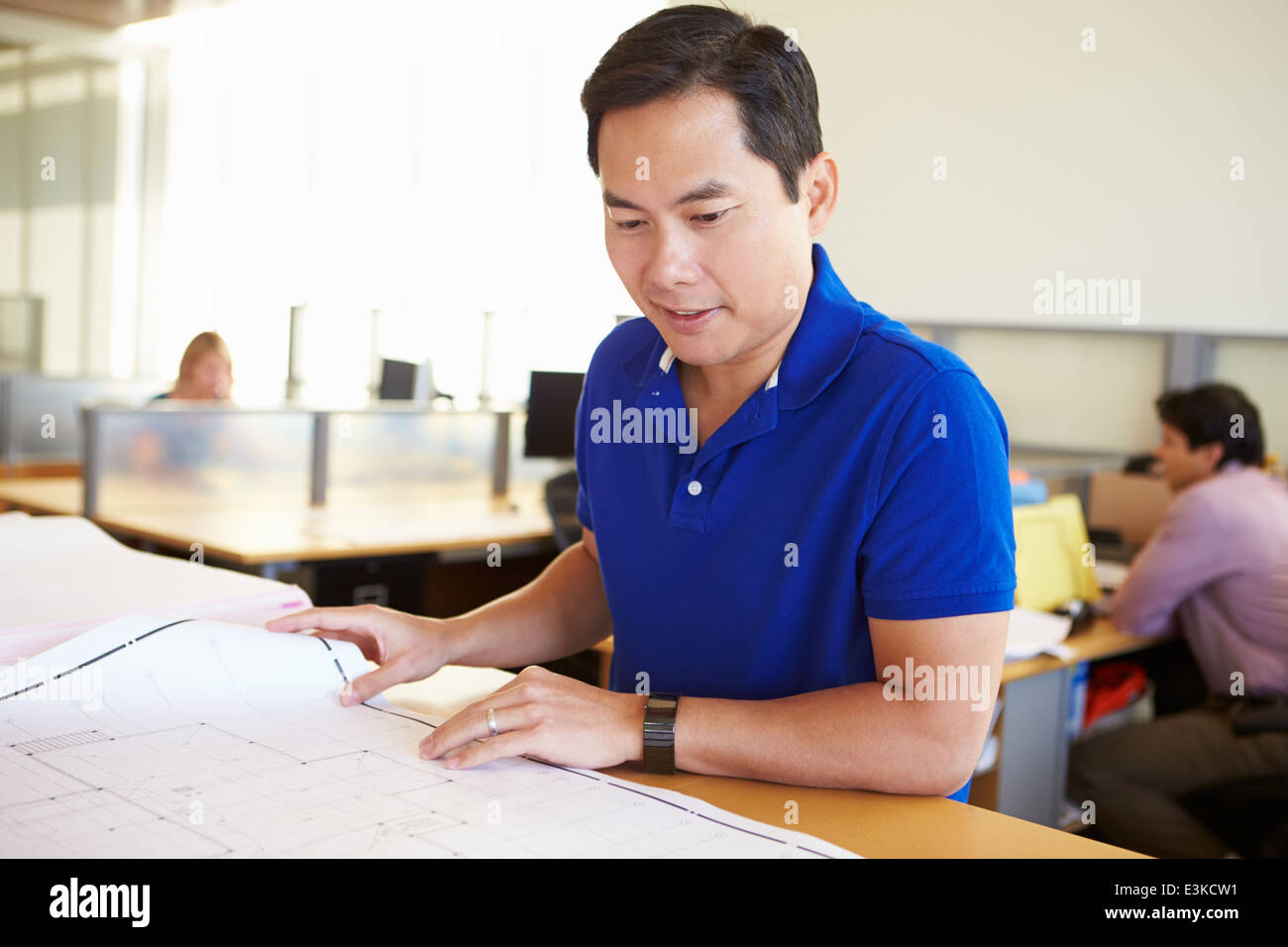 Arquitecto masculino estudiando planes en Office Foto de stock