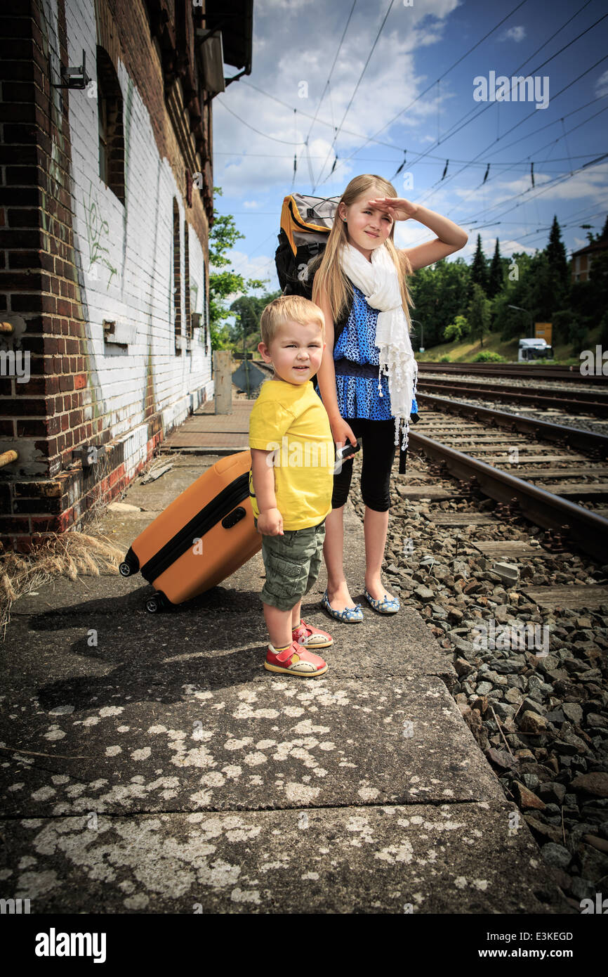 Los niños esperando el tren en una estación de tren Foto de stock