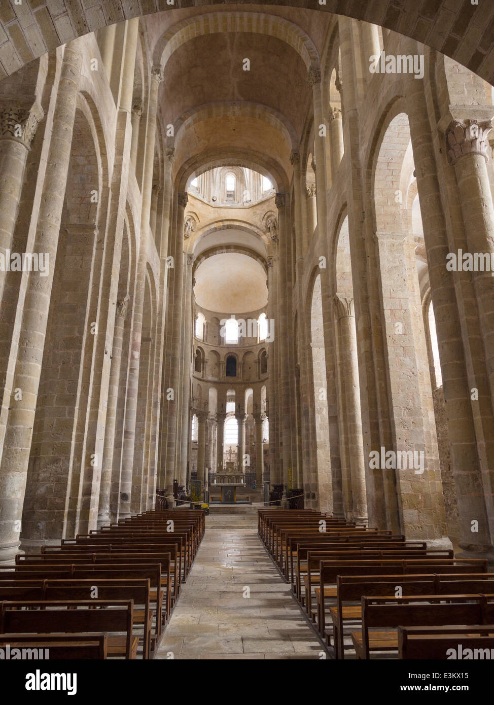 El austero interior el pasillo central de la iglesia de Sainte Foy . Las columnas se disparan y la llanura mampostería interior brilla Foto de stock