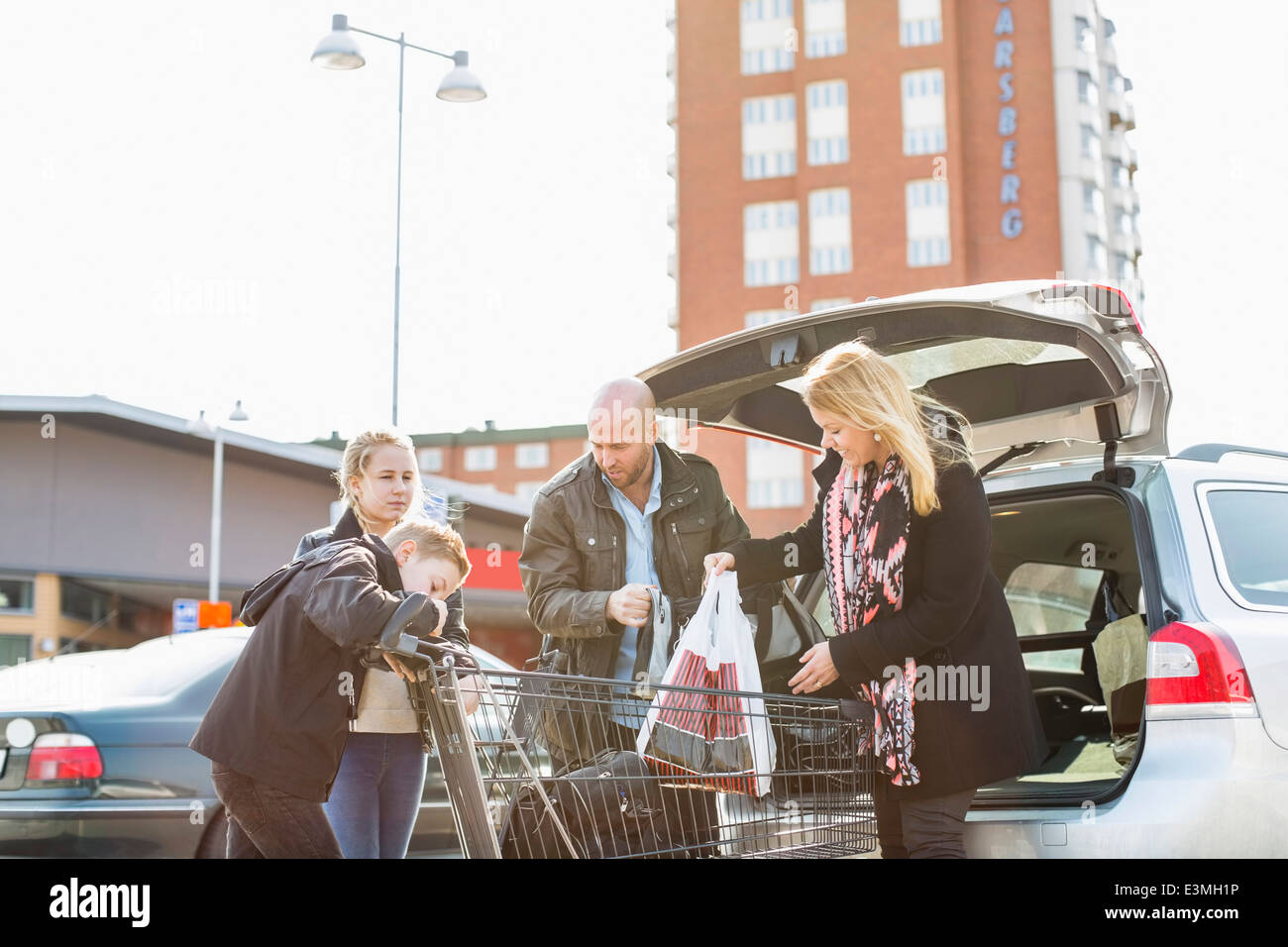 Familia comestibles en carga del maletero del coche en un aparcamiento Foto de stock