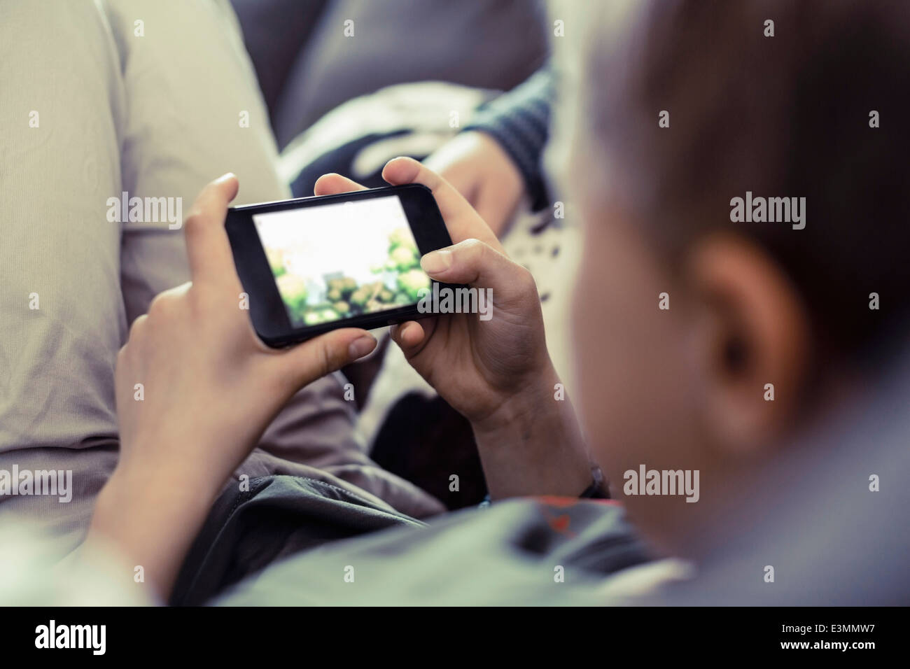 Niño jugando en el teléfono móvil en el hogar Foto de stock