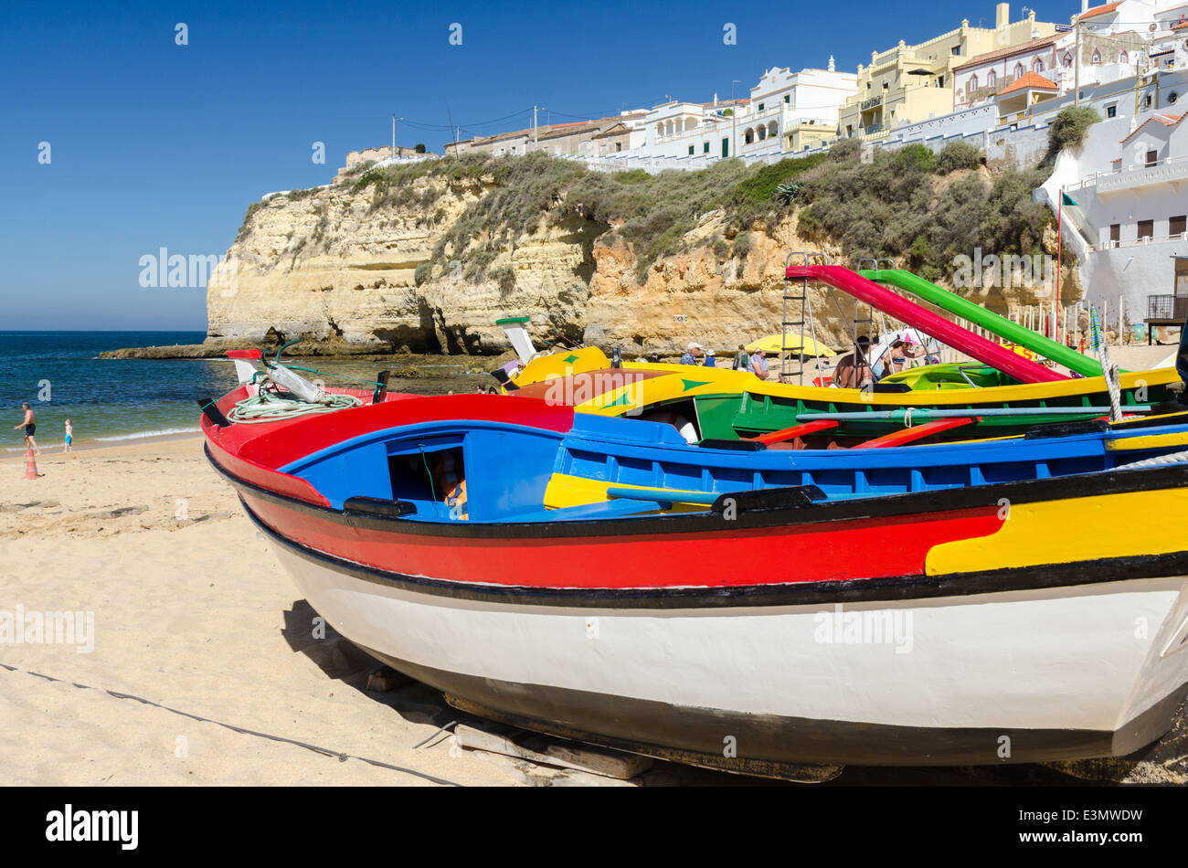 Botes de pesca de madera pintada en colores brillantes en la playa, en el  bonito pueblo de Carvoeiro Algarve Fotografía de stock - Alamy