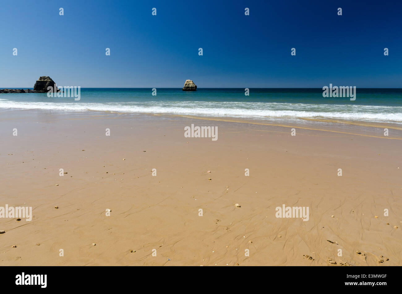 Gran extensión de arena y cielo azul profundo en Praia da Rocha, Portimao, en el Algarve Foto de stock