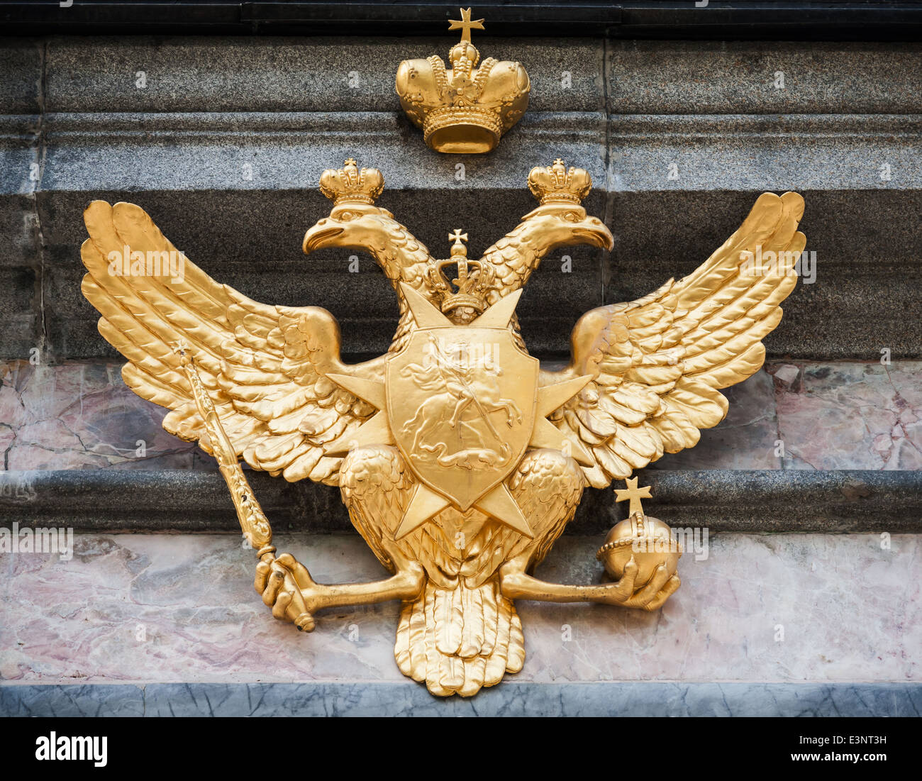 Doble águila dorada en muro de piedra. Escudo de armas de la Federación de Rusia Foto de stock