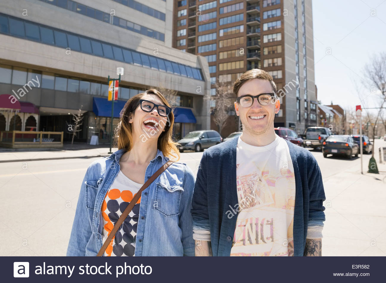 Hipster par riendo en la soleada calle urbana Foto de stock