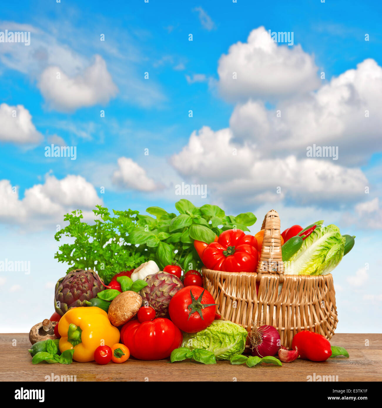 Las verduras frescas y las hierbas más hermoso cielo azul. Cesta de la compra con los ingredientes de los alimentos orgánicos Foto de stock