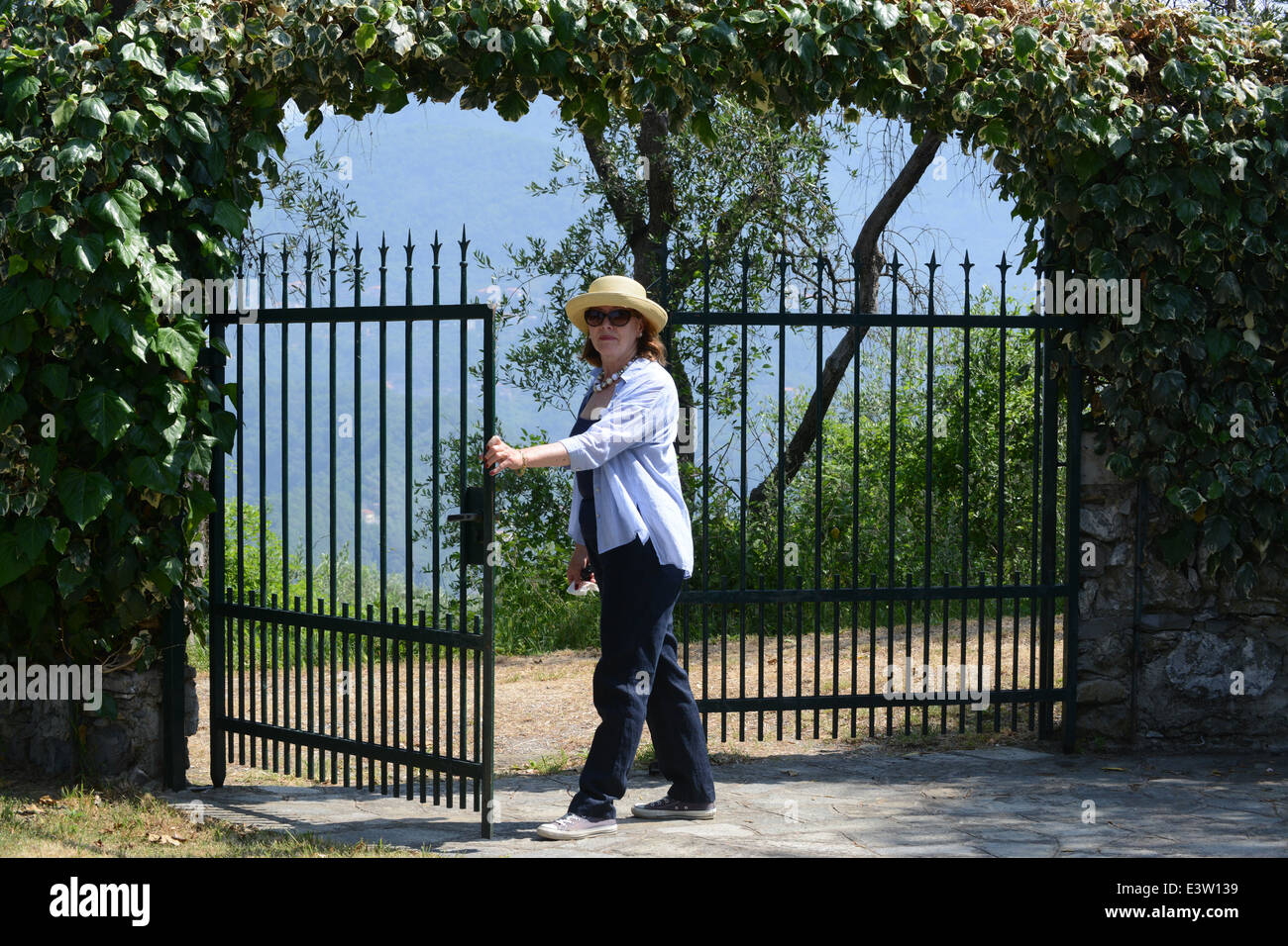 Mujer apertura puerta de seguridad propiedad casa jardín portones Foto de stock