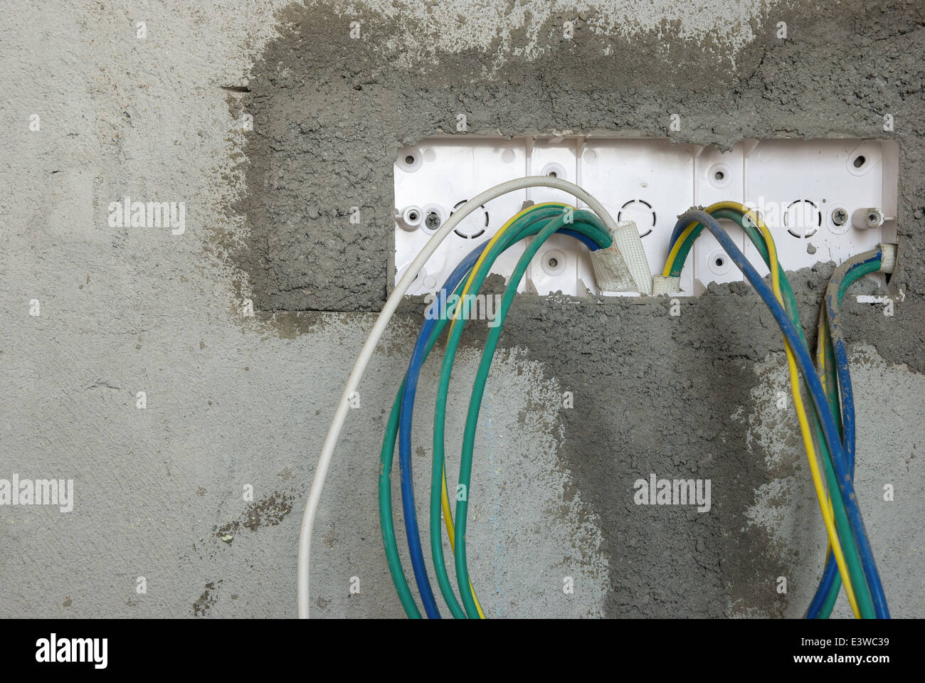 Toma de cable eléctrico inconclusa en la pared Foto de stock