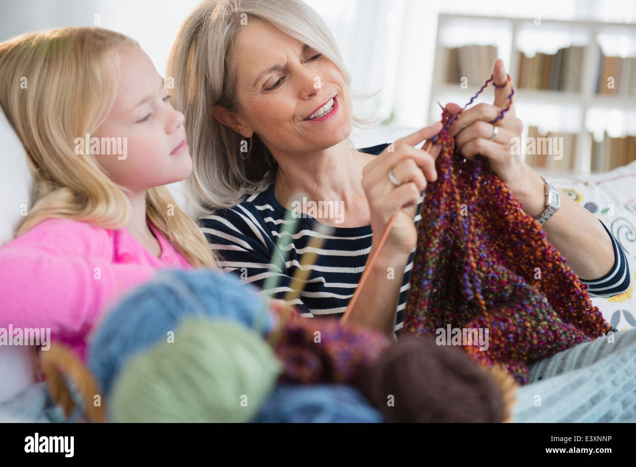 Senior mujer caucásica y nieta tejiendo en el sofá Foto de stock