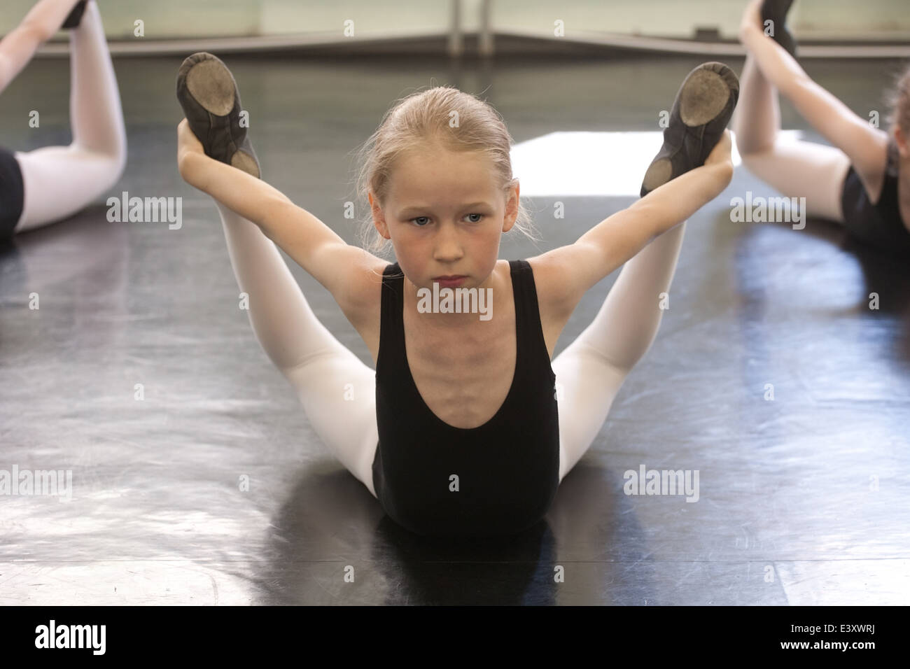 Ballet pequeñas niñas formación ejercicio coreográfico en el piso Foto de stock