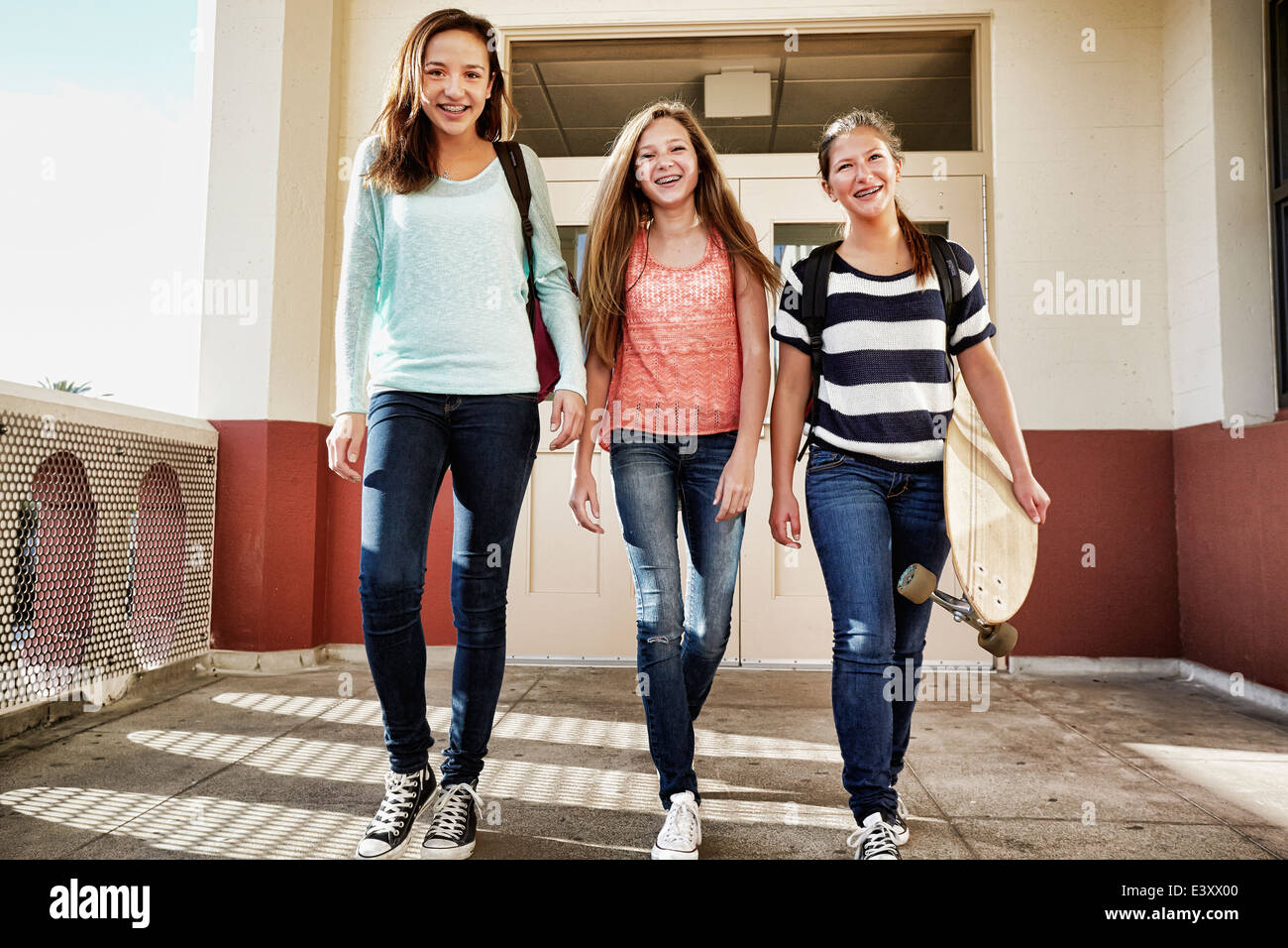 Las adolescentes caminando por el campus de la escuela Foto de stock