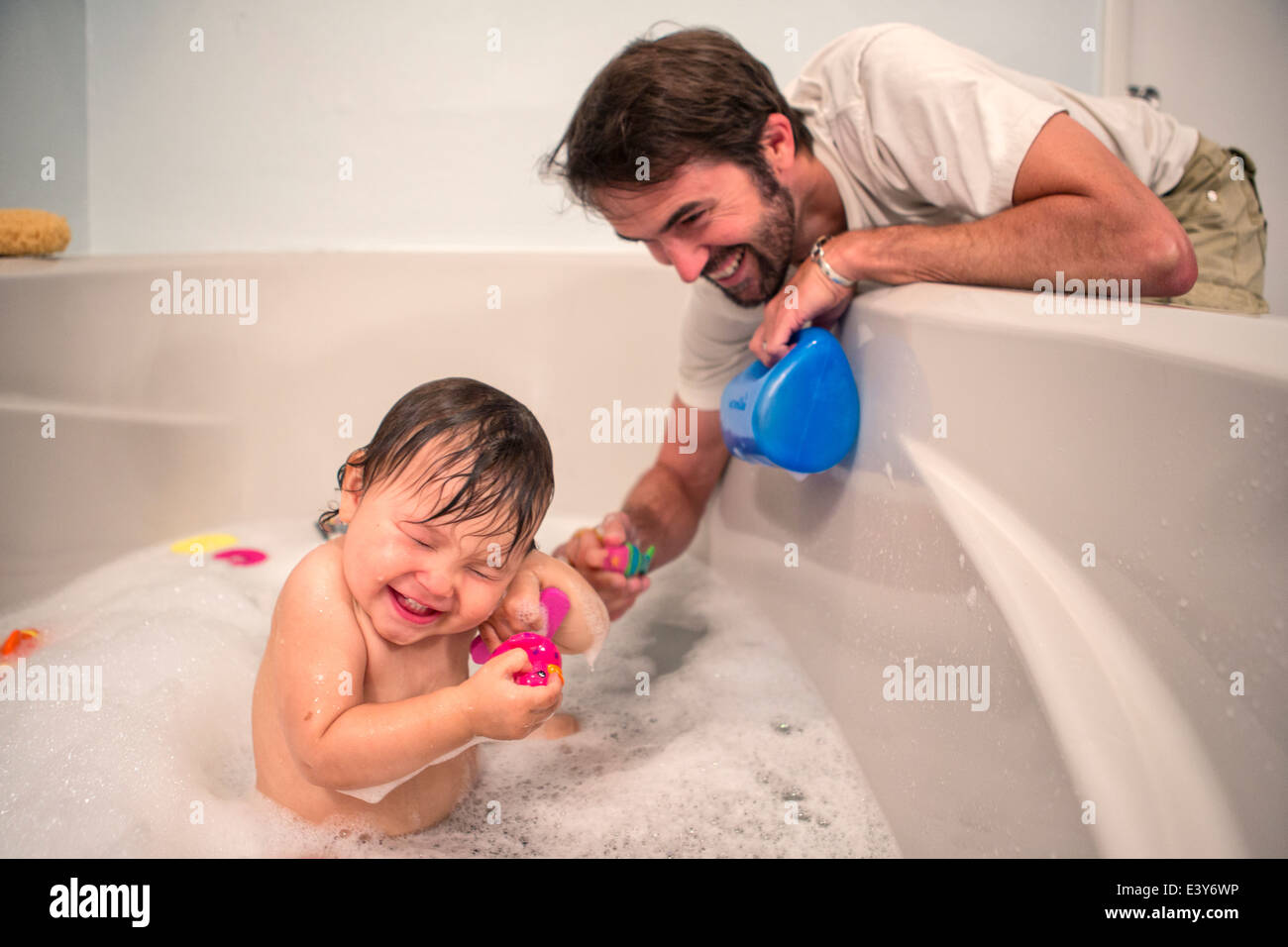 Padre e hija niño jugando en el momento del baño Foto de stock