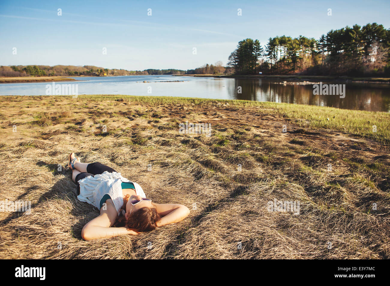 Mujer joven tomando el sol en la hierba de Kittery, Maine, EE.UU. Foto de stock