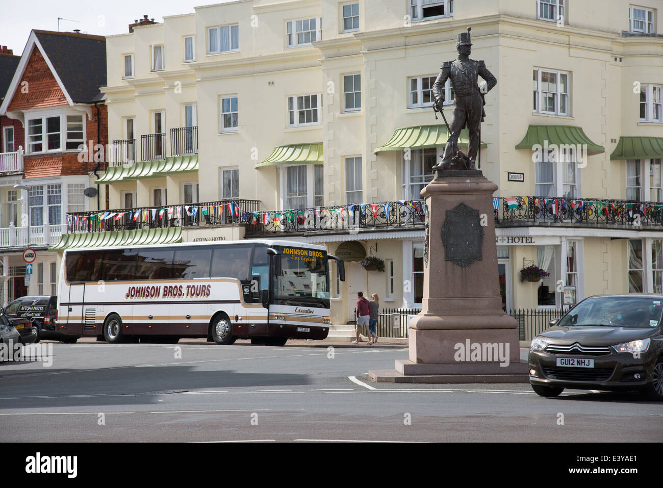 Resorts en inglés entrenador vacaciones fuera del hotel y la estatua de Regimiento Royal Sussex 1920 en Marine Parade, Eastbourne East Sussex Foto de stock