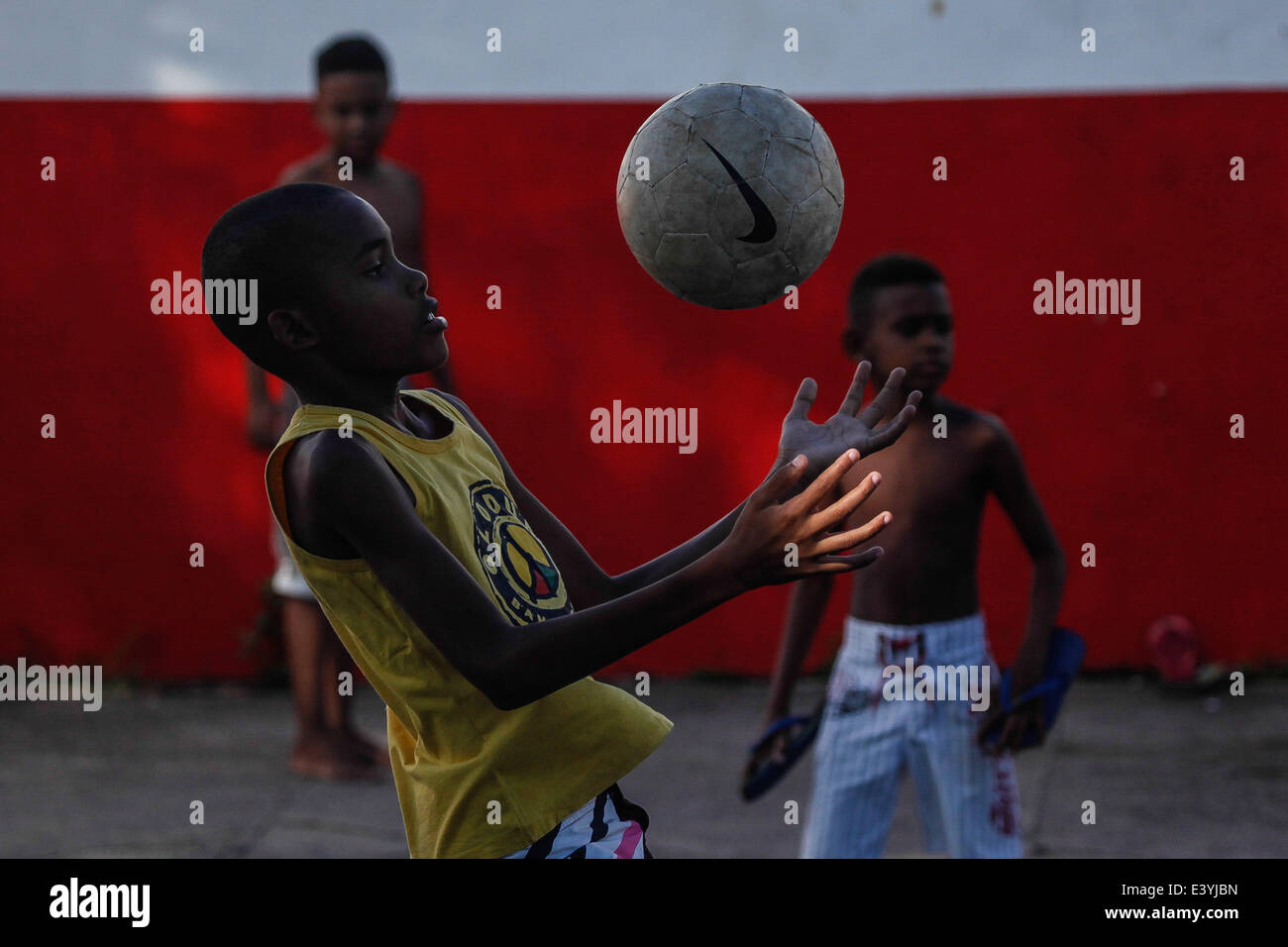 (140701) -- El Salvador, 1 de julio de 2014 (Xinhua) -- Los niños juegan al fútbol en una calle en Salvador, Brasil, el 1 de julio de 2014. (Xinhua /Jhon Paz)(pcy) Foto de stock