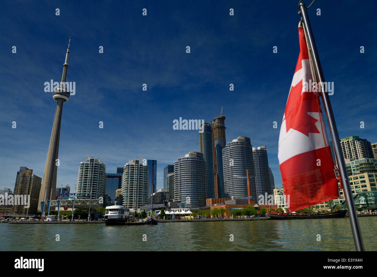 Bandera canadiense en un barco con el horizonte de Toronto CN Tower y Harbourfront en Lago Ontario Foto de stock