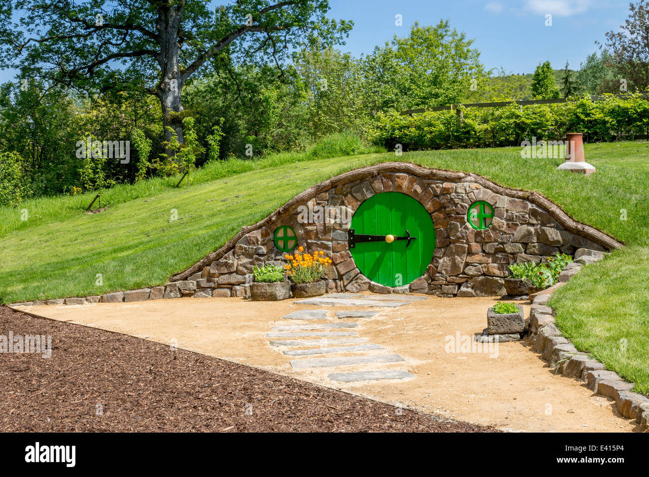 Agujero hobbit con puerta redonda y Chimney Pot Foto de stock