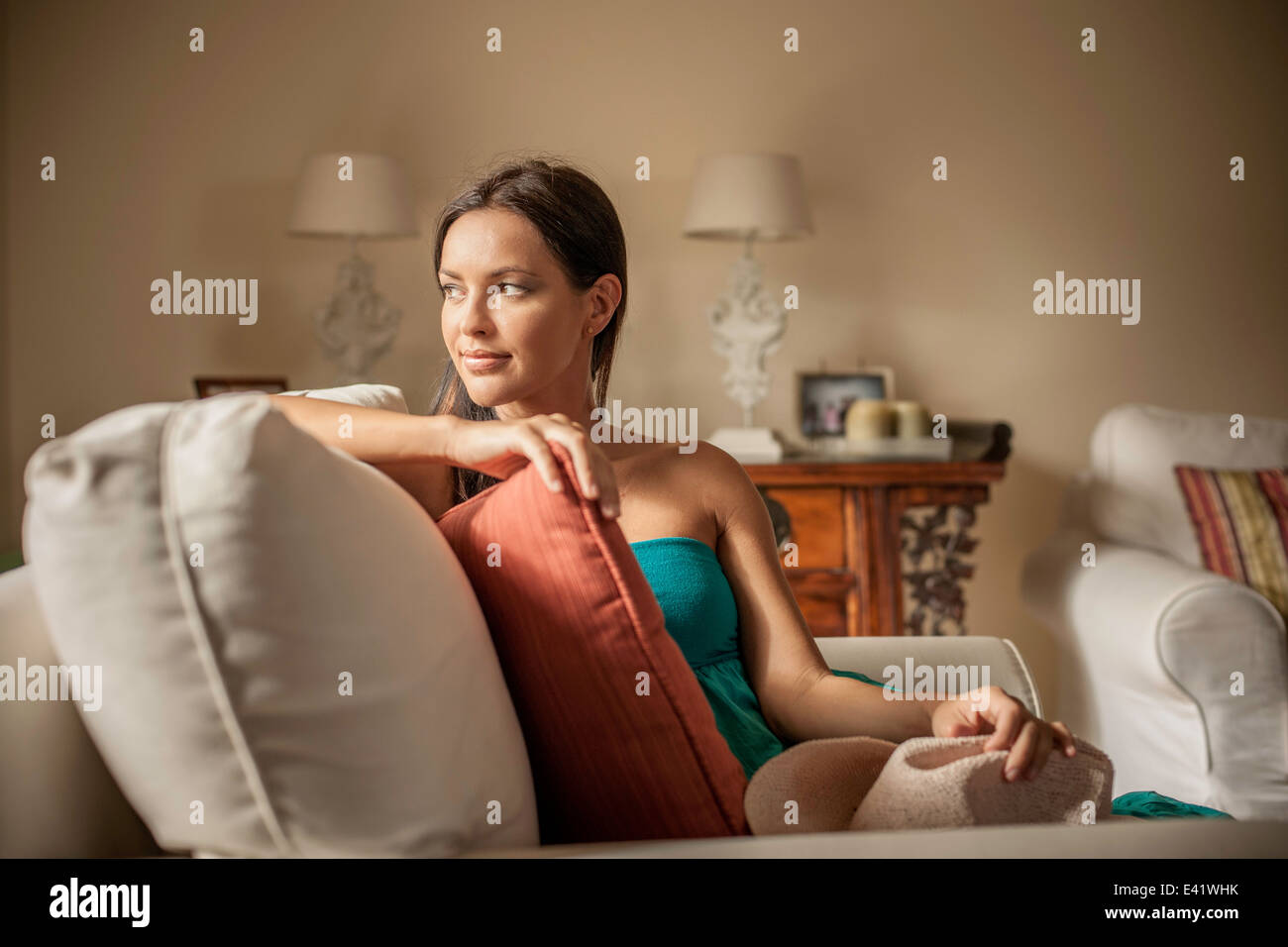 Contemplativo joven mujer sentada en un sillón Foto de stock