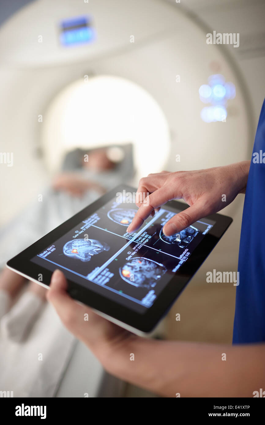 Radiógrafo mirando escaneo cerebral en tableta digital de imagen Foto de stock