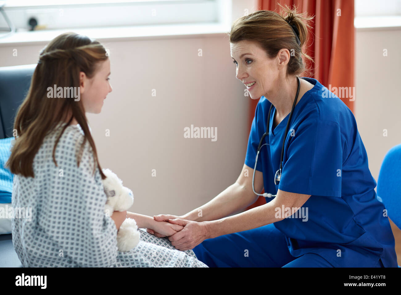 Enfermera hablando a niña Foto de stock