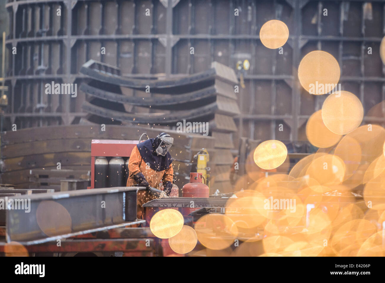Trabajador de la construcción metálica de molienda en la fábrica de fabricación marina Foto de stock