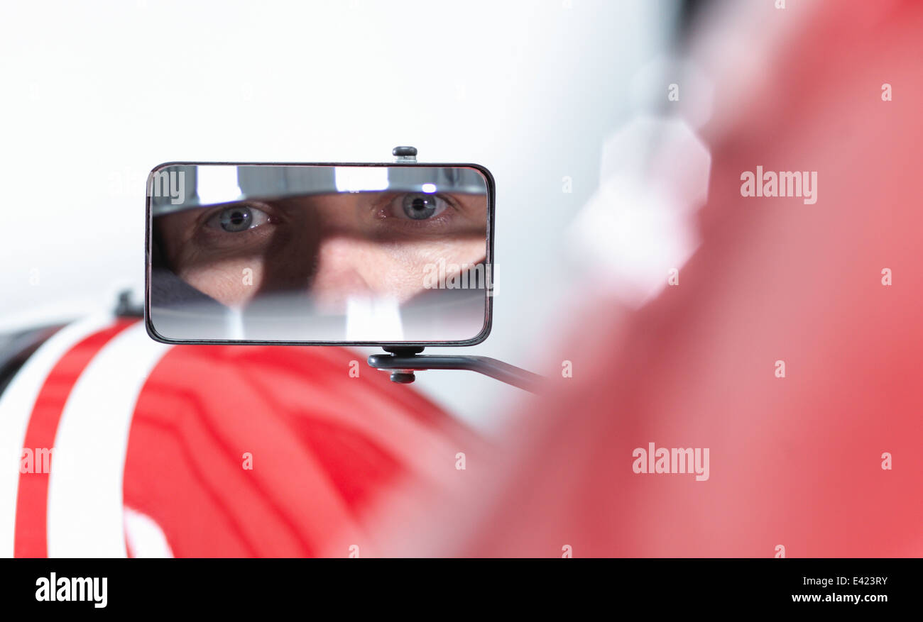 Retrato del conductor del coche de carreras se refleja en espejo de ala de supercar Foto de stock
