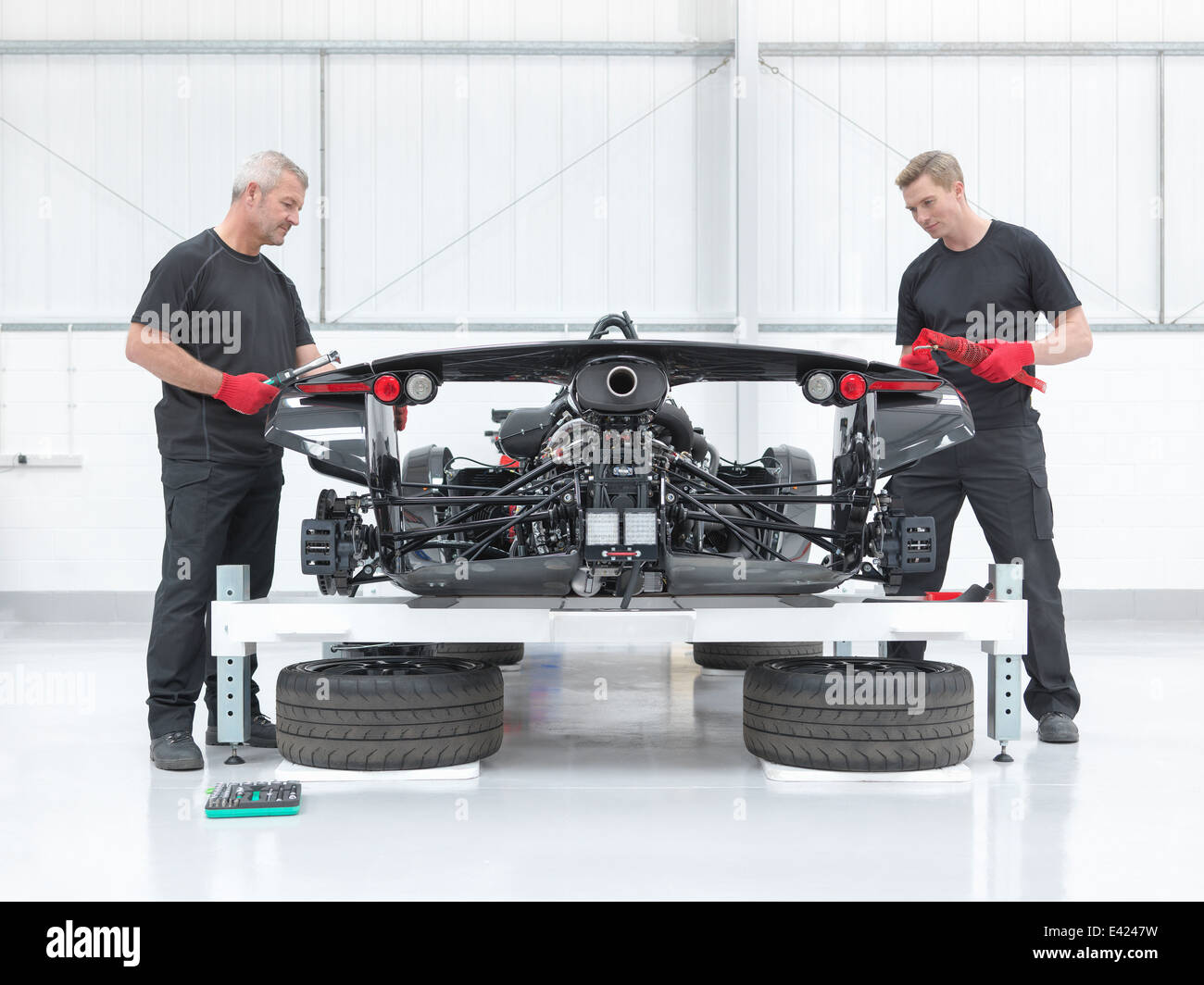 Dos ingenieros montaje supercar en fábrica de coches deportivos Foto de stock