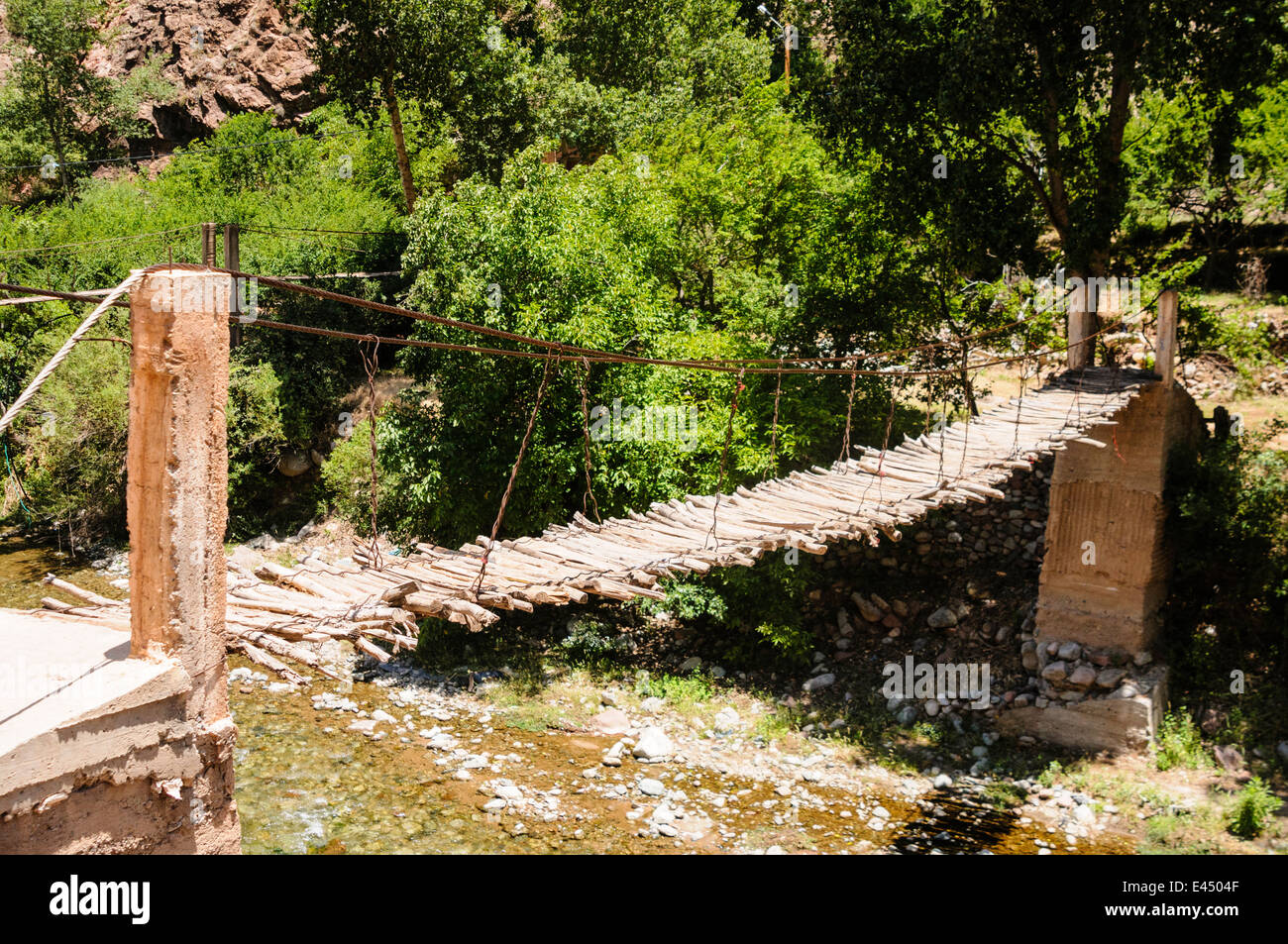 Un potencialmente peligroso destartalado puente sobre el río Ourika, Valle de Ourika, las montañas del Atlas, Marruecos Foto de stock