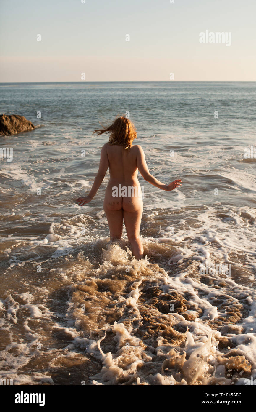 Vista trasera de una mujer adulta media desnuda corriendo en el mar con el  Matador Beach, Malibu, California, EE.UU Fotografía de stock - Alamy